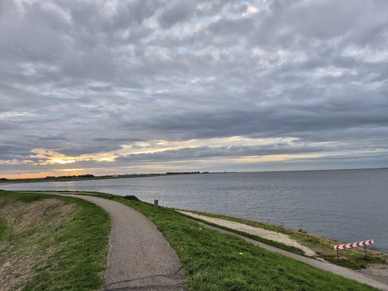 Yerseke 2026: Deichweg im Abendlicht mit dichter Wolkendecke über dem Wasser
