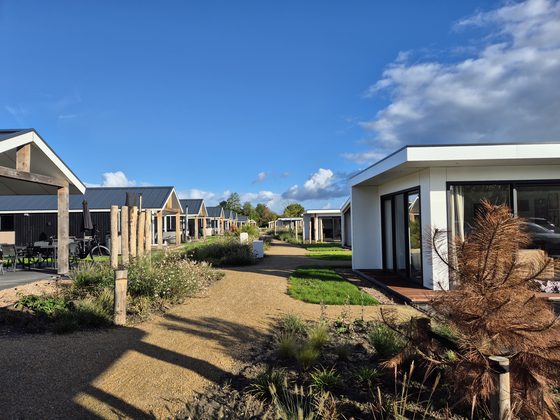 Yerseke 2026: Ferienpark mit Chalets und Kiesweg unter blauem Himmel